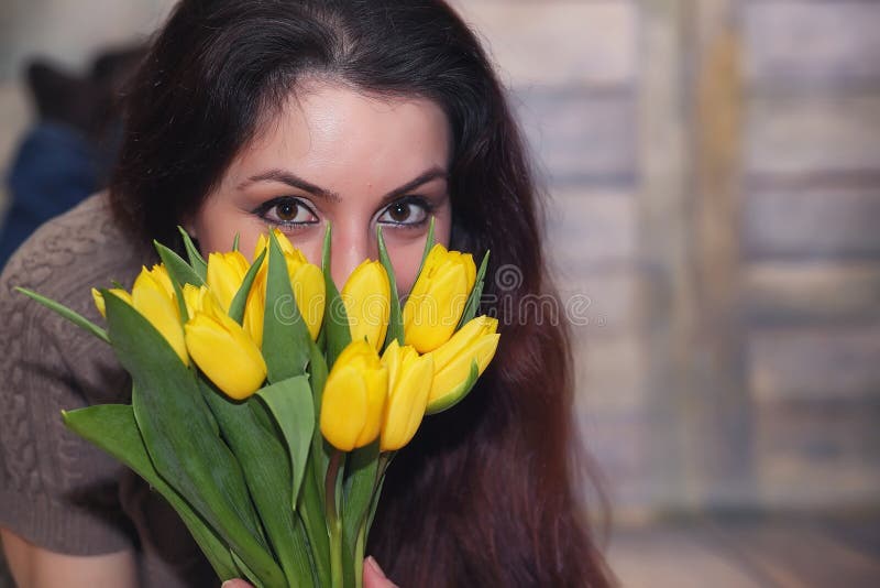 Желтые тюльпаны в руках девушки