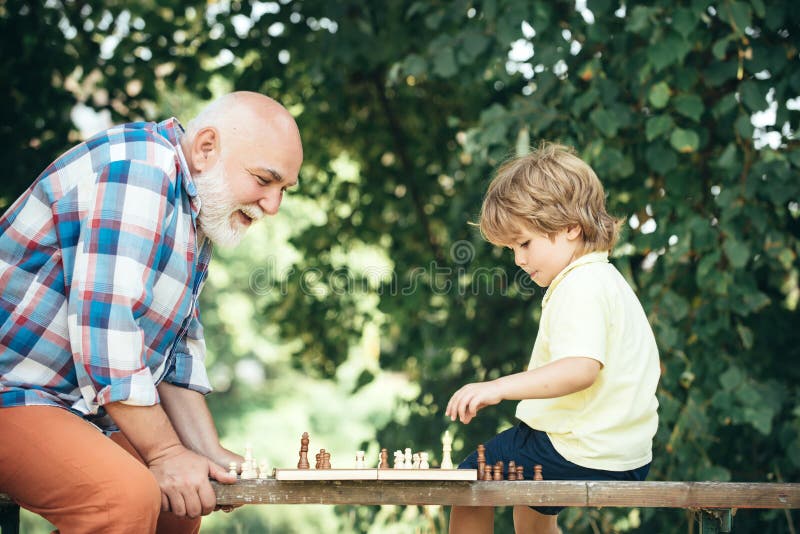 Дед с внуком играют в шашки. Дедушка с шахматами. Дедушки играют в шахматы. Дедушка и внук играют в шахматы. Мальчик играет в шахматы с дедом.