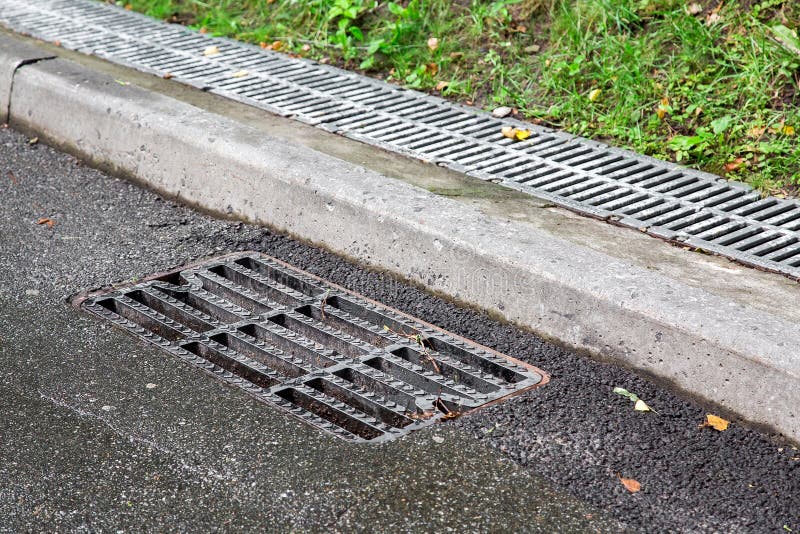 Metal Drain Cover near the Curb. City Rain Drainage.