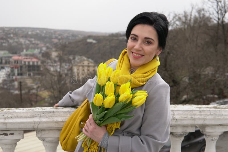 Желтые тюльпаны в руках девушки