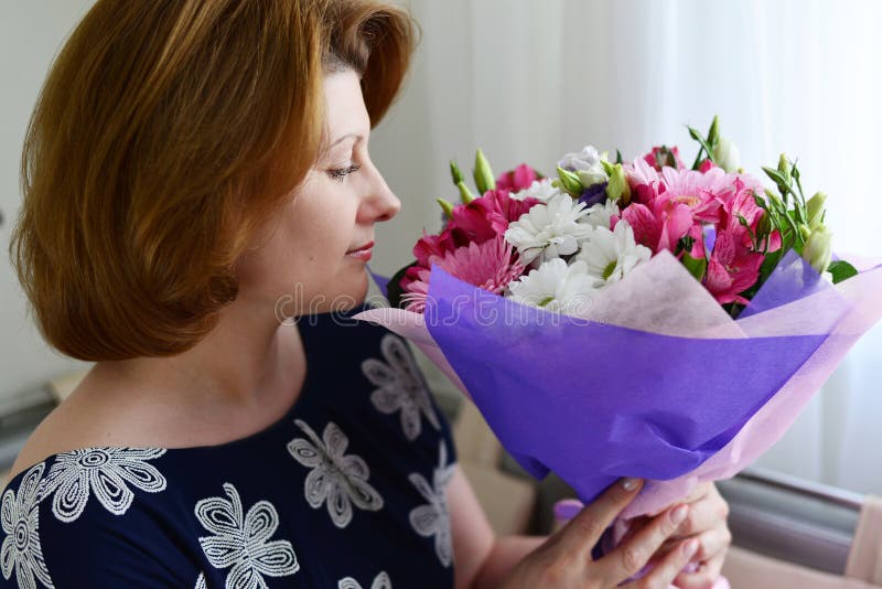 Женщина нюхает букет