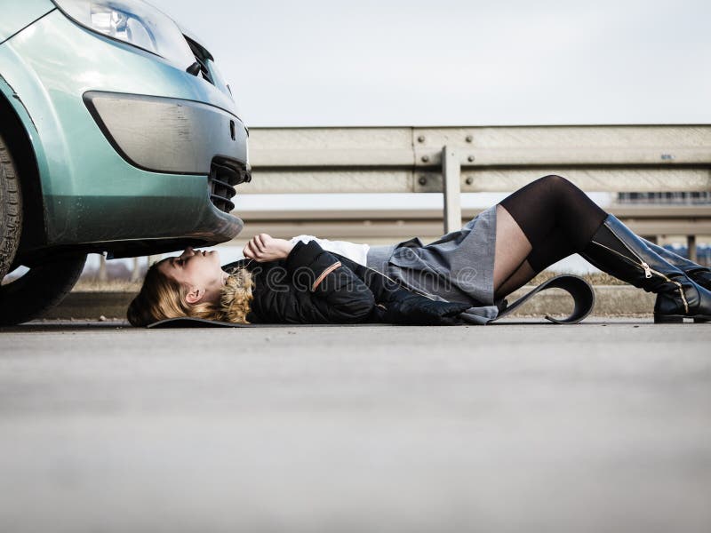 Женщина разбила машину. Девушка лежит под машиной. Девушка разбила машину.