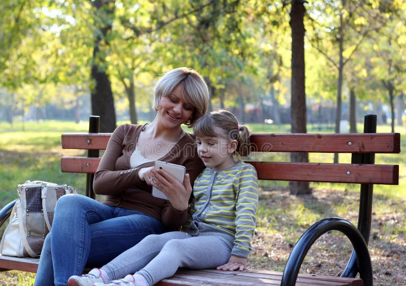 Дочка сидит на маме. Мама с дочкой на лавочке. Мама и дочка в парке на скамейке. Мама с дочкой сидят на лавочке. Фотосессия мать и дочь на скамейке.