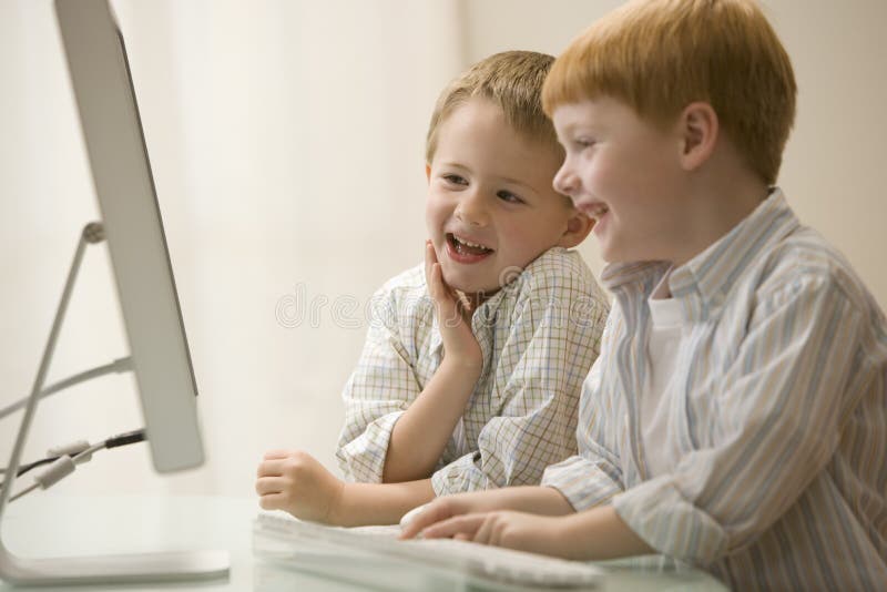 My brother plays computer games. Two brothers Play. Brothers playing stock photo.