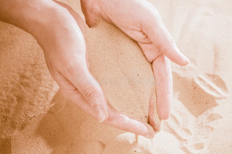 Сыплется. Песок в женской руке. Рука сыпет песок. Песок сквозь руки. Струйка песка и женские руки.