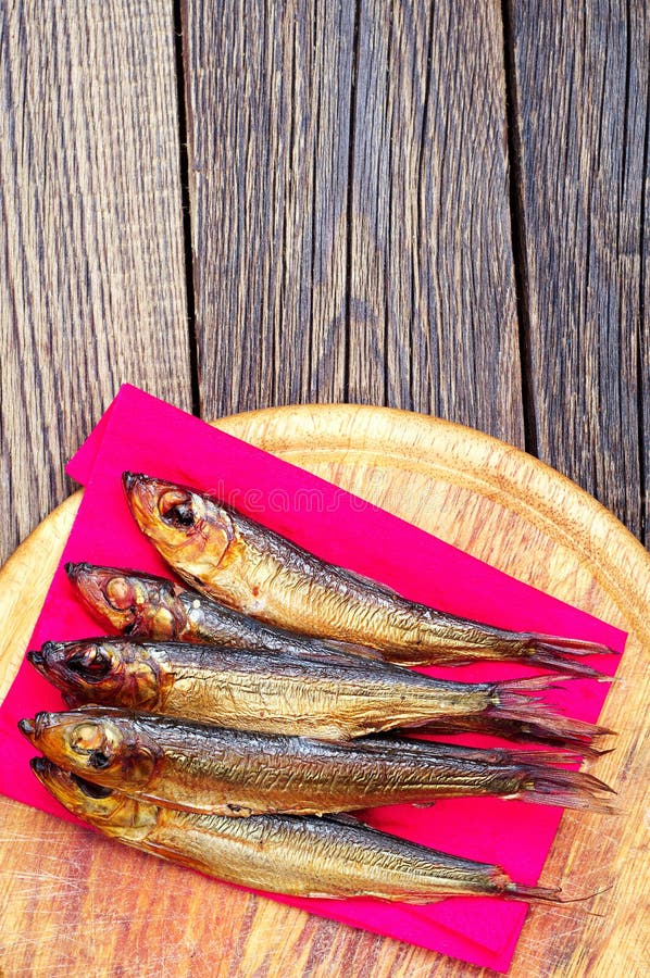 Шпрот копченый. Дома копченая рыба на разделочной доске. Smoked Fish on Table.