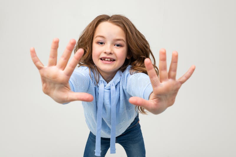 Девочка в толстовке показывает лайк руками. Черно белая картинка маленькая девочка с раскинутыми руками в поле.