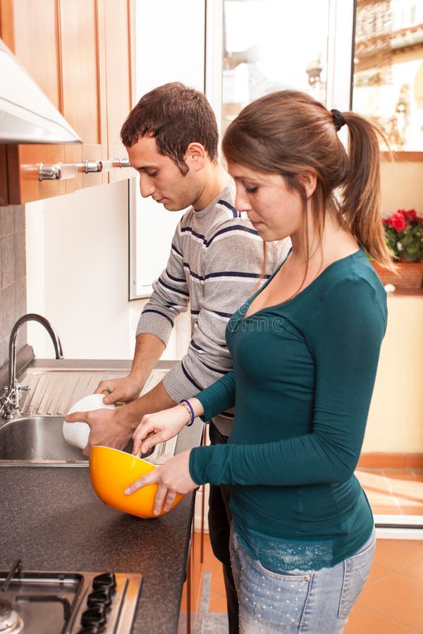 Муж с женой на кухне занимаются. Муж моет посуду. Муж моет посуду под присмотром жены. Жена готовит муж на диване. Муж на диване жена на кухне.
