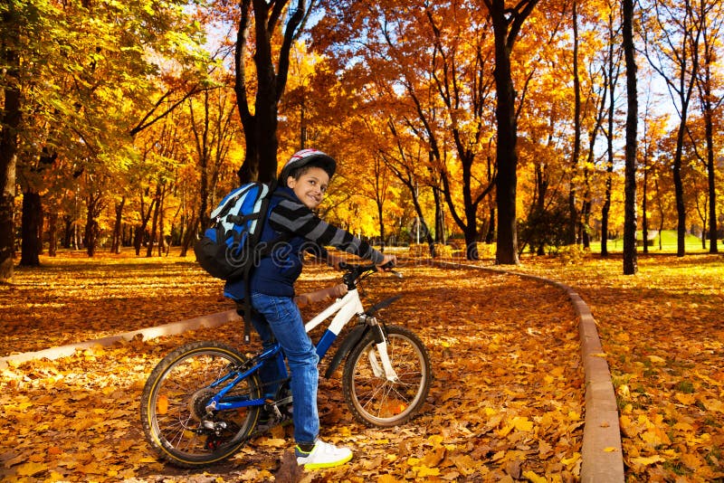 Мальчик сидит на велосипеде. Велосипед школьник. Осенний парк на велосипеде. В школу на велосипеде. Едет на велосипеде в школу фото.