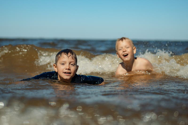 Мальчик купается в море. Плавание мальчики.