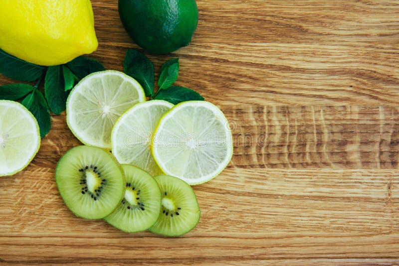 листья желтого лимона и зеленого лайма и мяты киви на деревянной доске  Стоковое Фото - изображение насчитывающей вегетарианец, нож: 221309236