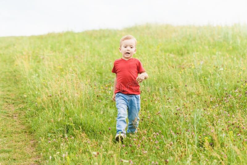 Побежал по земле. Мальчик бежит. Мальчик бежит по траве. Маленький мальчик бежит по полю. Дети бегут по лужайке.
