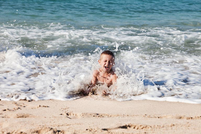 Мальчик купается в море. Мальчик лежит на берегу моря. Мальчик на море в волнах. Маленькие дети купаются в море.