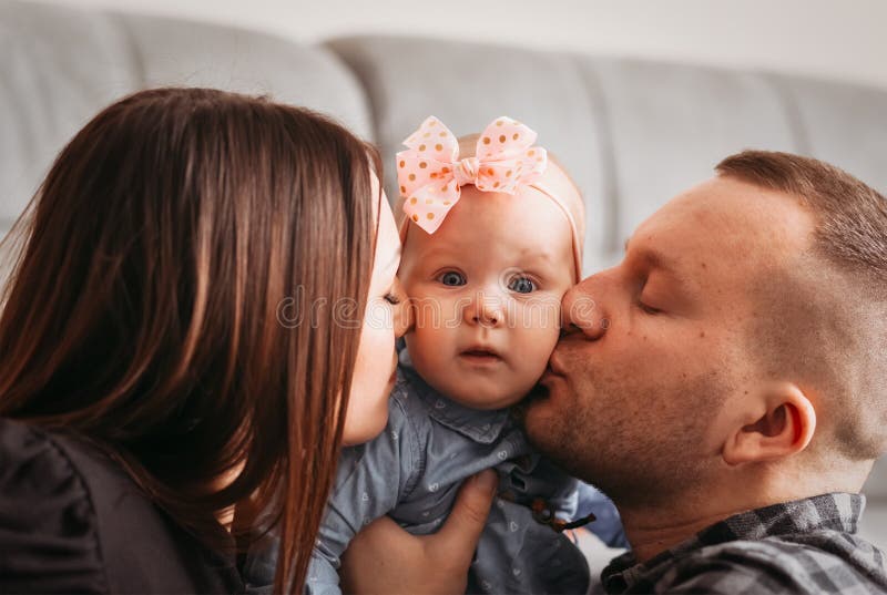 Дорогой нежный папа. Маленькая дочь сасётся с папой. Папа целует дочку в щечку фото новорожденной.