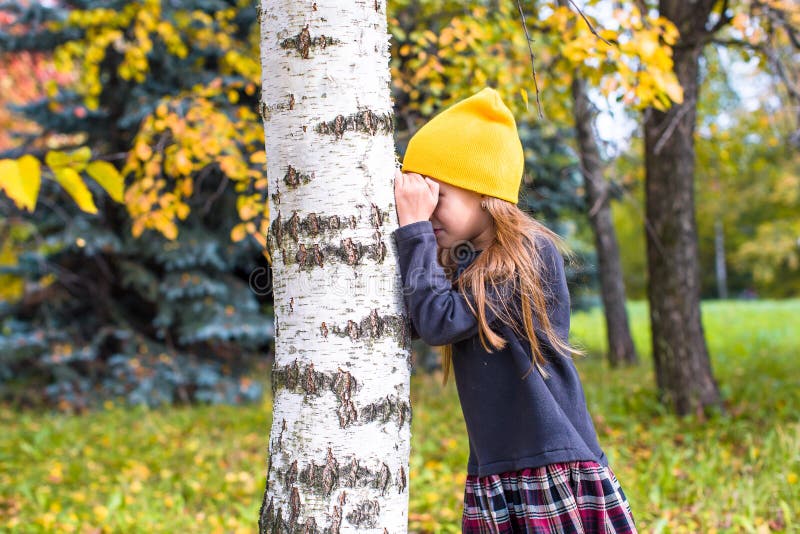 Играть в прятки на улице. ПРЯТКИ осенью. "ПРЯТКИ". ПРЯТКИ фото. Маленькая девочка около дерева.