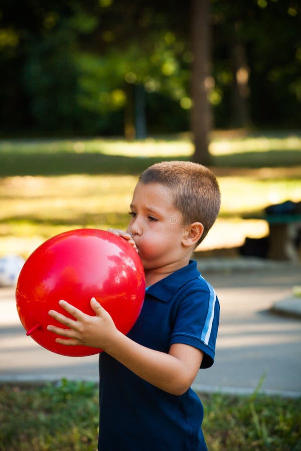Мальчик с большим шаром. Надувает шарик. Мальчик надумает шарик. Ребенок надувает воздушный шарик. Шарики для мальчика.