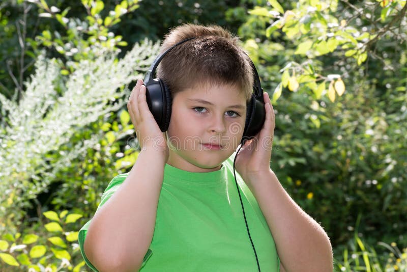 Слушать мальчики полностью. Ребенок в наушниках. Мальчик слушает музыку в наушниках. Подростки в парке в наушниках. Мальчик слушает музыку фото.