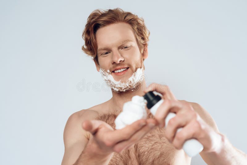 Мужчина мажет крем. Мужская гигиена. Мужчина наносит гель для бритья. Носки и пена для бритья на 23 февраля.