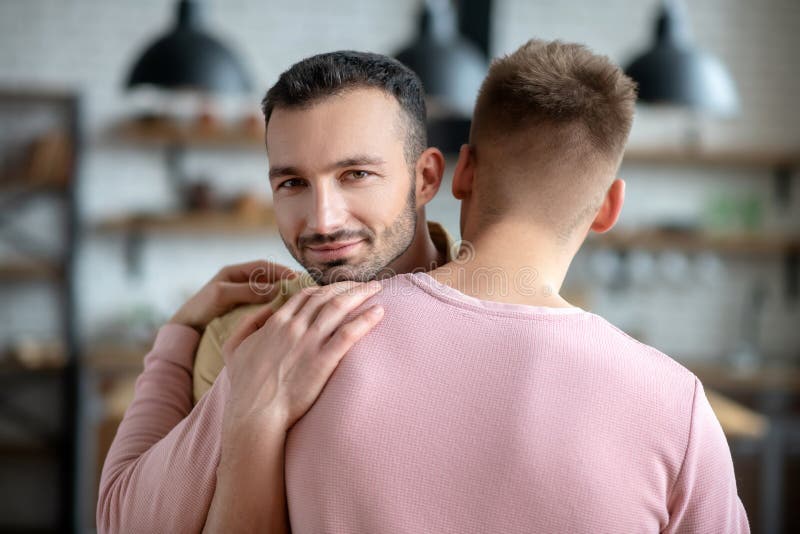 Two men hugging each other. Two men hugging. Two young men