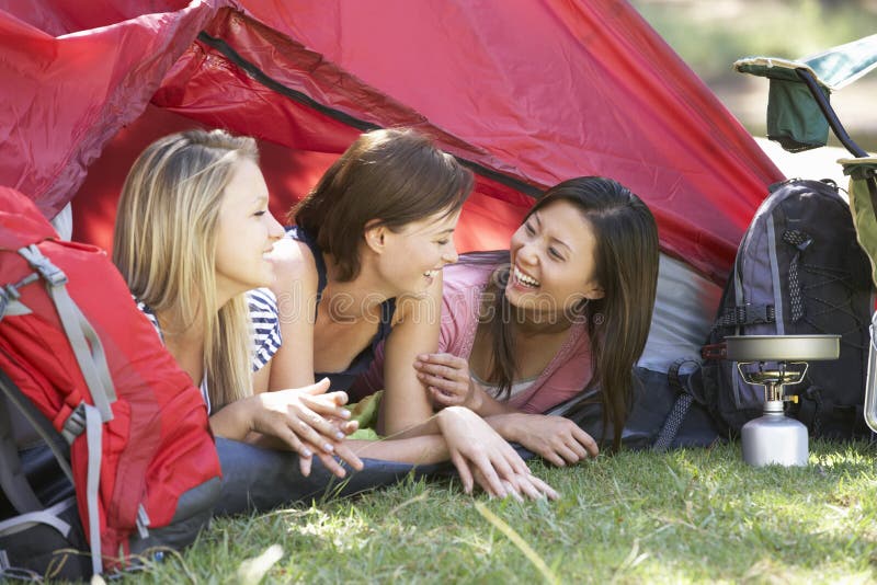 3 молодой женщины на располагаясь лагерем празднике совместно стоковые фото...