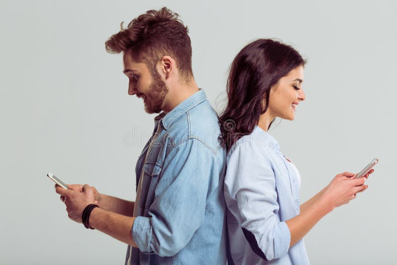C friend using. Мужчина и женщина стоят. Спина к спине с телефоном. Девушка парень смартфон. Мужчина со смартфоном.