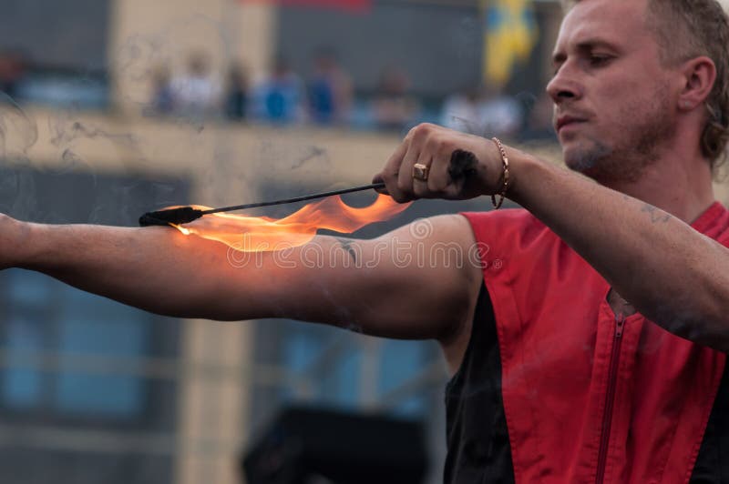 Факела горят в руках мод. Человек жонглирует водой и огнем. Фото ремонта горящего факела.