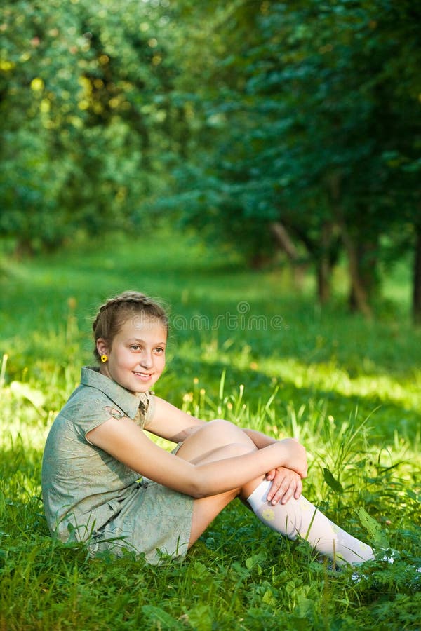 Молодой девушка сидят лице. Девочка сидит на траве. Девушка сидит на траве. Подросток сидит на траве. Девочка подросток сидит на траве.