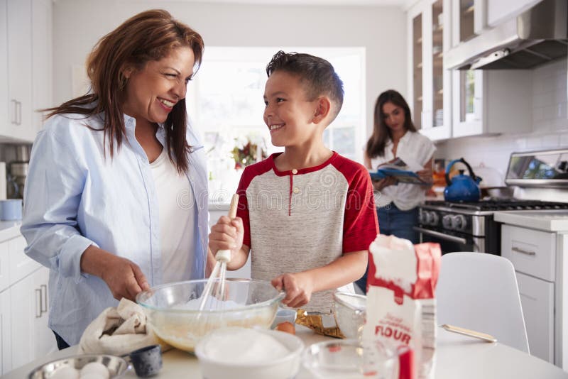 Мальчик делает торт. Торт и кухня на заднем плане. Mum with children Cooks. Family with Baking. Маму стоя на кухне