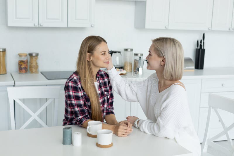 Lesbians drinking coffee in bed