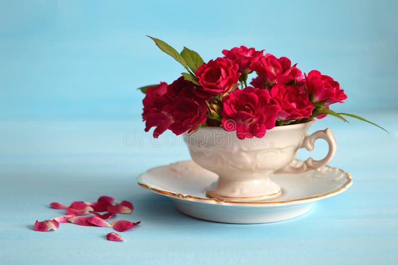 Розы в чашке чая на голубой предпосылке Стоковое Изображение - изображениенасчитывающей флористическо, кровопролитное: 64500309
