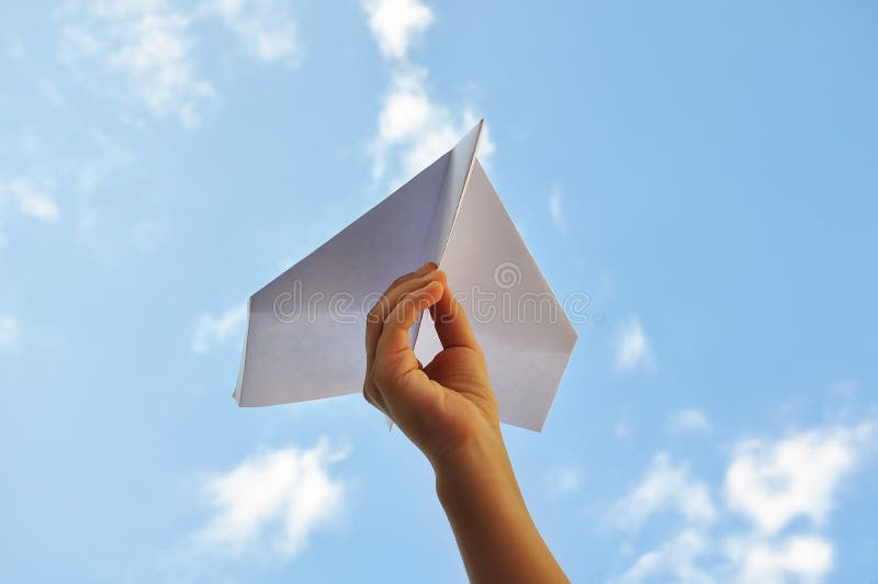 Над бумажным над листом. Бумажный самолетик в небе. Бумажный самолетик в руке. Фотосессия с бумажными самолетиками. Рука с бумажным самолетиком на фоне неба.