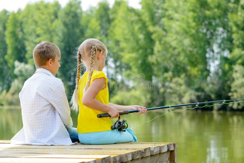 День летней рыбалки. Ловим лето. Two girls Fishing on a Wooden Pier. Hobby Fishing. Лове на лету