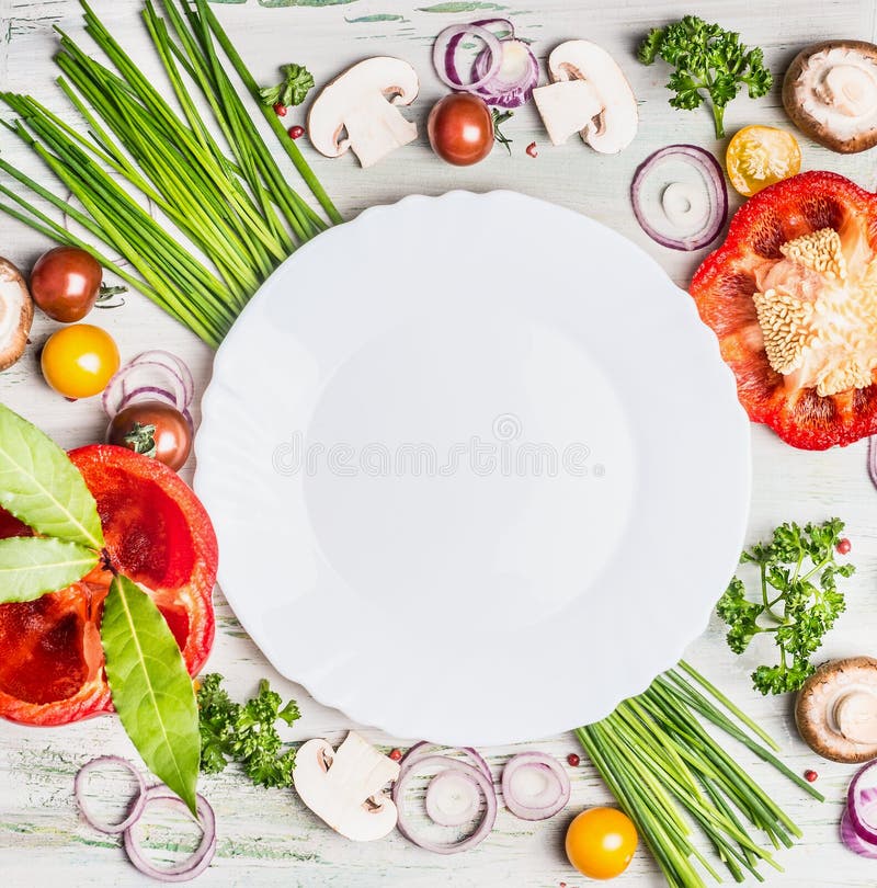  Свежие органические овощи и ингридиенты приправой для вкусного вегетарианца варя вокруг пустой белой плиты, взгляд сверху стоковые изображения