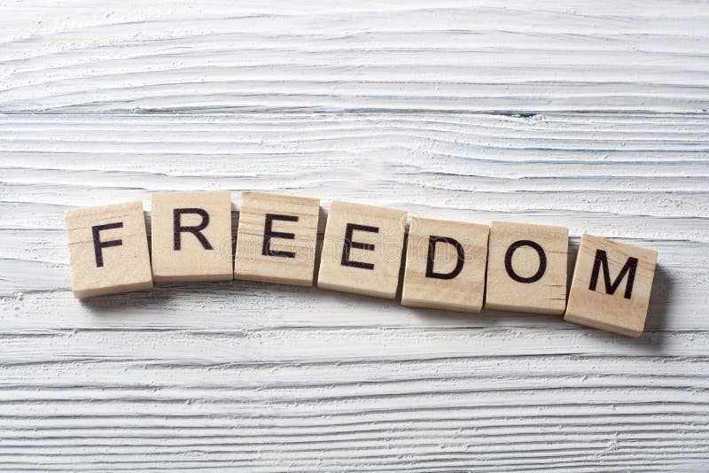 Слово Freedom. Свободное слово. Свободно слово. Белые буквы на деревянном фоне фото.
