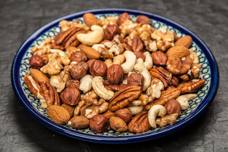 Assorted Nuts, Almonds, Pistachios, Walnuts, Hazelnuts and Figs on a Black Ceram