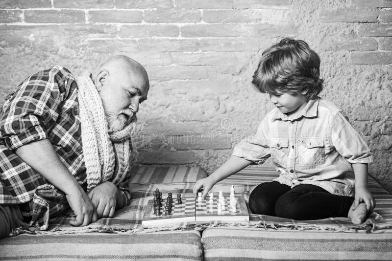 Дед с внуком играют в шашки