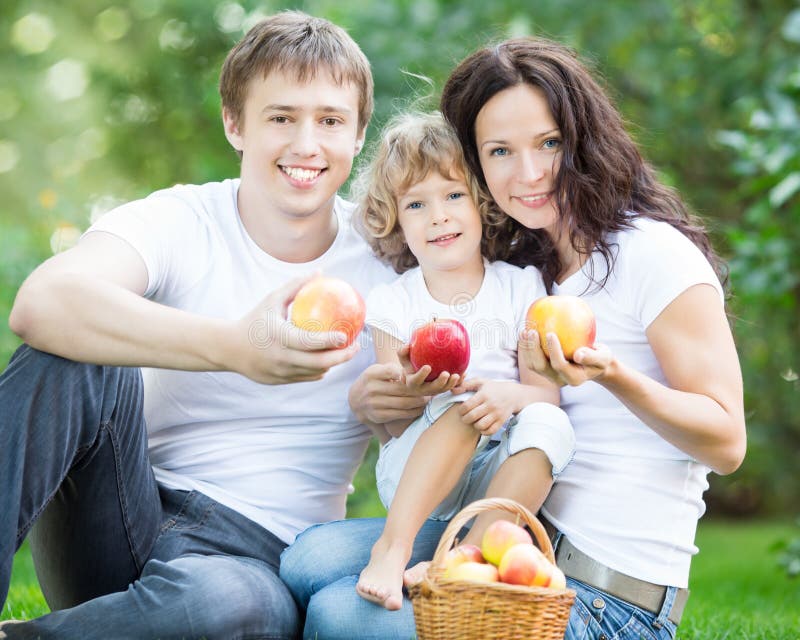 Туристы отец мать и два близнеца. Семья в корзинке с яблоками. Семья ест яблоки. Фотосессия с яблоком и семья. Счастливая семья в парке.