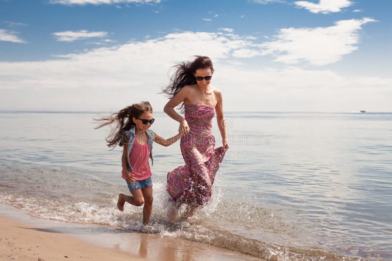 молодая мама с дочкой на пляже. девочки с мамами на пляже. девочки с мамами на пляже. мама с дочкой на песке. красивая девочка с мамой на пляже.