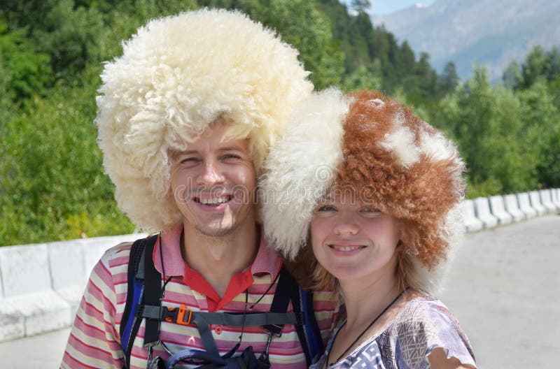  Счастливые туристы нося смешные шляпы овец стоя на горе roa стоковое фото rf