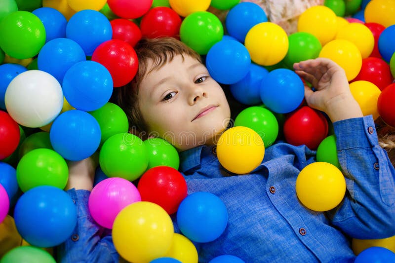 Шарами яма. Фото детей с разноцветным мячом. Дети лежат в бассейне с шарами. Дети с разноцветными мячами занимаются. Мальчик в яме с шариками.