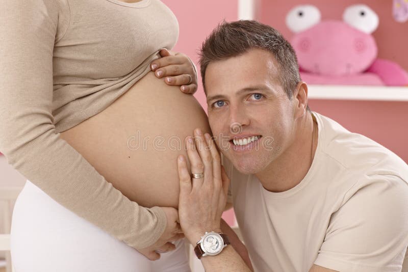Весь в отца слушать. The mother is holding her belly, the fetus.