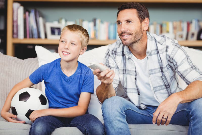 Сын наблюдает. Мужчина с сыном на футболе. Читает с сыном футбол. Папа и сын смотрят футбол.