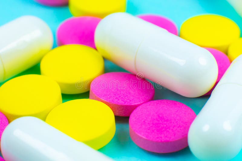 Цветные таблетки. Разноцветные таблетки на зеленом фоне. Успокоительные разноцветные таблетки. Гормональные препараты разноцветные таблетки.