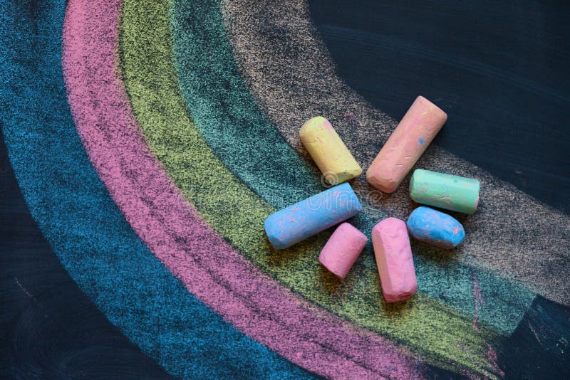 Рисунок мелом на доске домик с окнами. Беленная мелом. Белая доска с черными надписями. Дети играют на поверхности. Детские рисунки мелом.