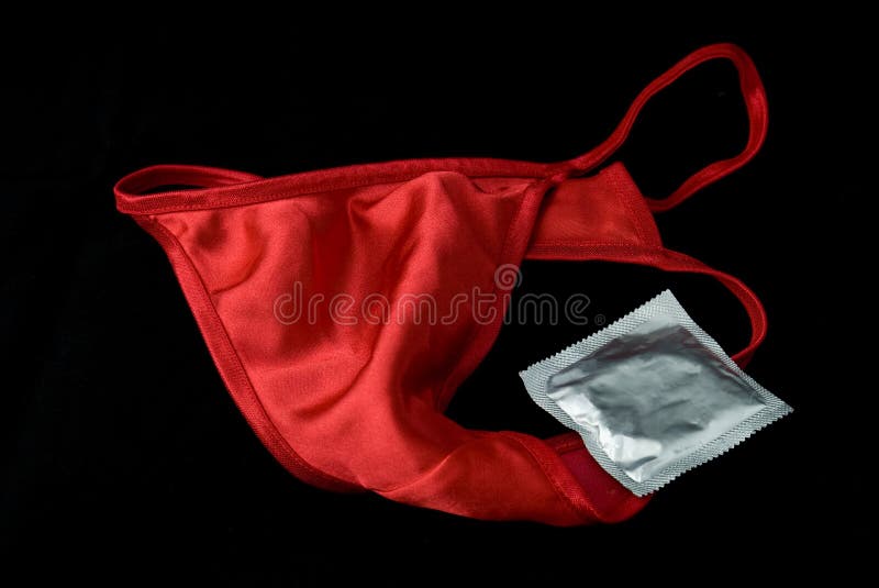 Розовые сексуальные трусы шнурка ` S женщин с презервативом на красной  предпосылке Стоковое Изображение - изображение насчитывающей управление,  влюбленность: 108106649