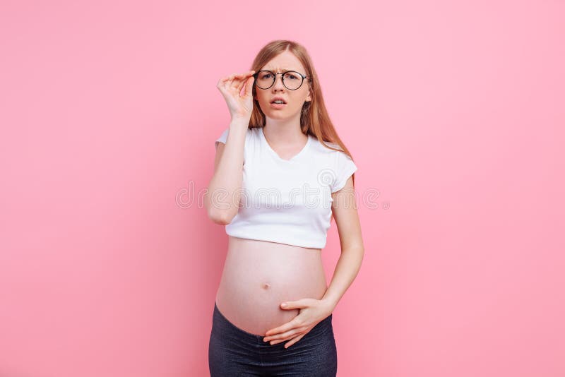 一件t恤杉的怀孕的女孩有视觉障害者的玻璃的在桃红色背景库存图片 图片包括有玻璃 眼睛