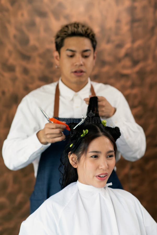 亚洲男性的美容师做亚洲女性客户的发型在曼谷市的现代美容院 库存照片 图片包括有成人 干净