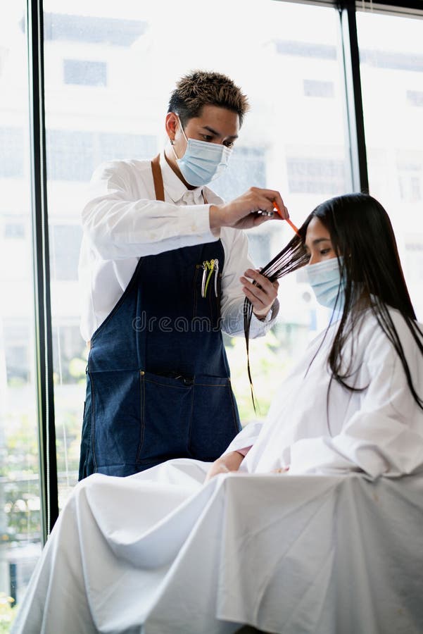 亚洲男性的美容师做亚洲女性客户的发型在曼谷市的现代美容院 库存照片 图片包括有成人 干净