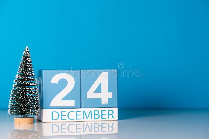 圣诞节12月25日天25 12月月 与一点圣诞树的日历在蓝色背景花雪时间冬天库存照片 图片包括有天25 12月25日