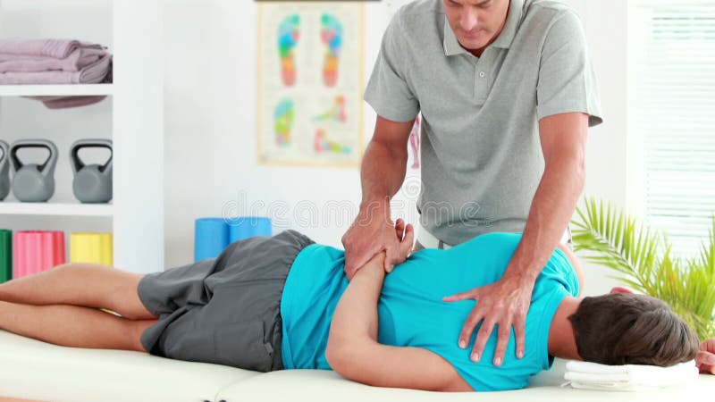 给体育按摩的生理治疗师患者影视素材 视频包括有给体育按摩的生理治疗师患者